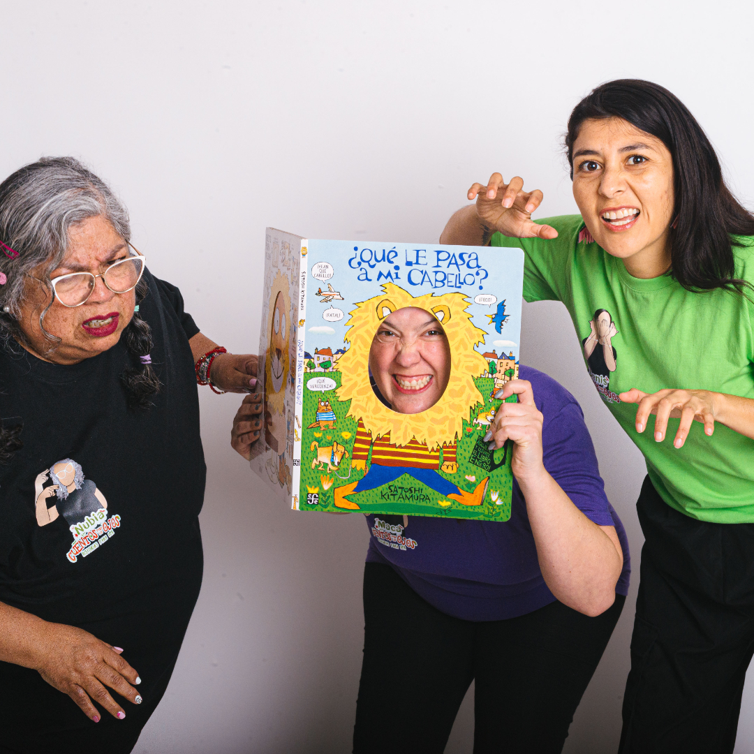 Narradoras de Cuentos para los Ojos jugando con el libro "¿Qué le pasa a mi cabello?"